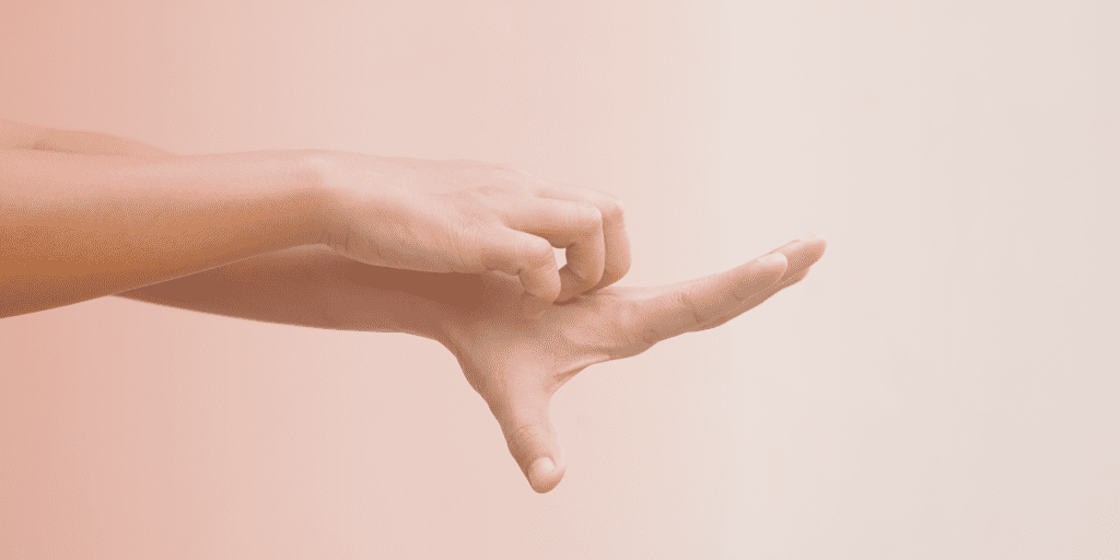 "A minimalist photograph showing a hand against a soft pink or peachy background. The hand is positioned horizontally with fingers extended, creating a simple, clean composition. The lighting is subtle and even, creating a gentle, calming aesthetic."