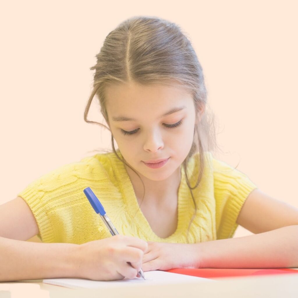 Petite fille aux cheveux longs, portant un pull jaune sans manches, en train d'écrie dans un cahier